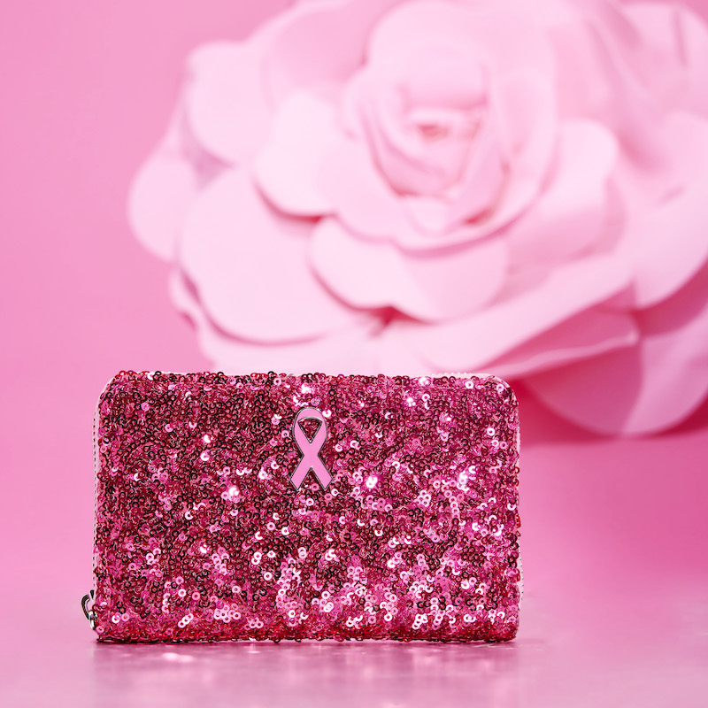 Image of our pink sequin Breast Cancer Research Foundation wallet against a pink background with a pink flower